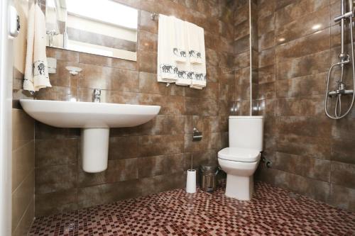 ein Badezimmer mit Waschbecken und Toilette in der Unterkunft Stella Del Mare Guest House in Kiten