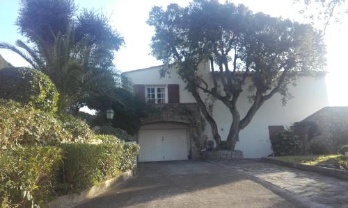 una casa blanca con un árbol y un garaje en Villa Savane en Ajaccio