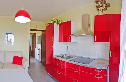 eine Küche mit roten Schränken und einem Waschbecken in der Unterkunft La Quiete 23 Lake view apartment by Gardadomusmea in Tremosine sul Garda