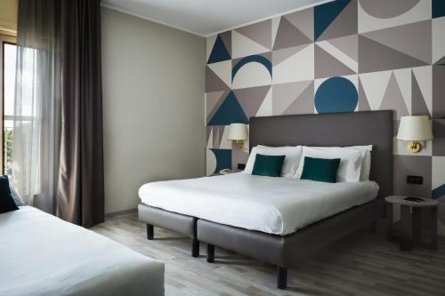 pokój hotelowy z 2 łóżkami i ścianą geometryczną w obiekcie Hotel Beatrice w mieście Este