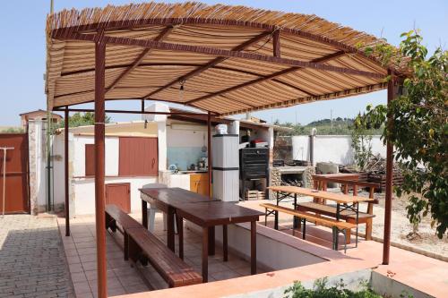 - un pavillon en bois avec des tables et des bancs sur une terrasse dans l'établissement Casa Vacanza Villa Sole, à Siculiana