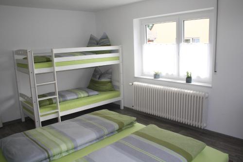 Zimmer mit 2 Etagenbetten und einem Fenster in der Unterkunft Ferienwohnung Hengl in Ettenheim