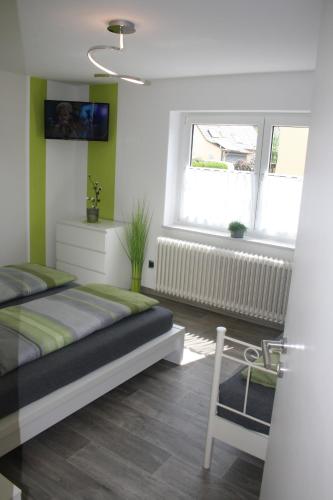 a bedroom with a bed and a window and a chair at Ferienwohnung Hengl in Ettenheim