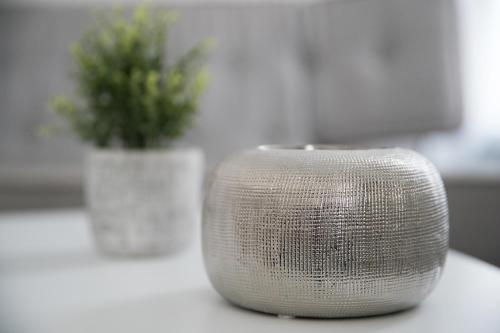 a silver object sitting on a table with a potted plant at Apart By Jo in Saint-Germain-en-Laye