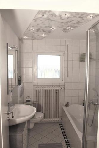 a bathroom with a sink and a tub and a toilet at Ferienwohnung Hengl in Ettenheim