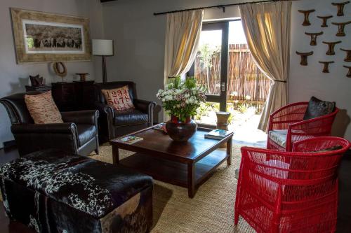 a living room with a couch and chairs and a table at Riverstone Lodge in Muldersdrift