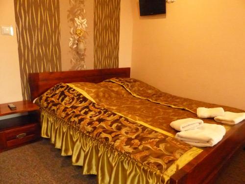 Una cama en una habitación de hotel con toallas. en Karczma Góralska, en Wisznice