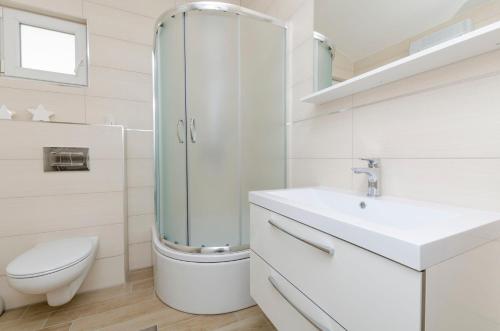 uma casa de banho com um chuveiro, um WC e um lavatório. em Apartments Dasa em Primošten