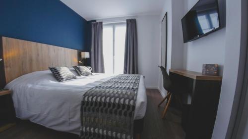 une chambre d'hôtel avec un lit et une télévision dans l'établissement Hôtel du Tramway, à Laon