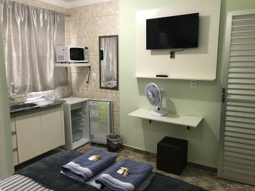 a small kitchen with two towels and a microwave at Hostel Trem de Minas in Belo Horizonte