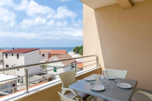 a table on a balcony with a view of the ocean at Apartments Danica in Primošten