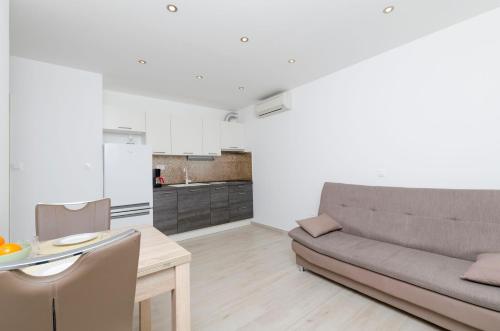 a living room with a couch and a table at Apartments Danica in Primošten