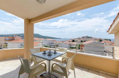 a balcony with a table and chairs and a view at Apartments Danica in Primošten