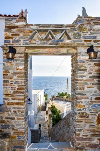 an entrance to a stone building with a view of the ocean at Anemos Sea View in Batsi