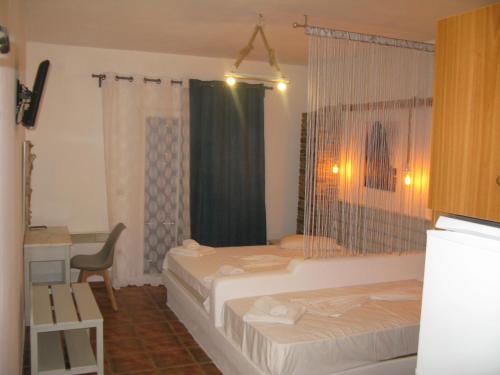 a bedroom with two beds and a desk and a chair at Anemos Sea View in Batsi