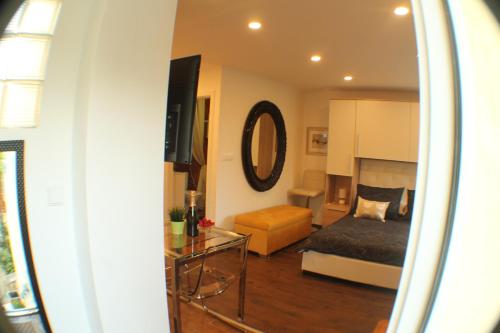 a living room with a bed and a room with a mirror at Amorino Apartman Studio in Opatija