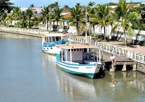 two boats are docked at a dock in the water at Casa de praia em Itanhaem in Itanhaém