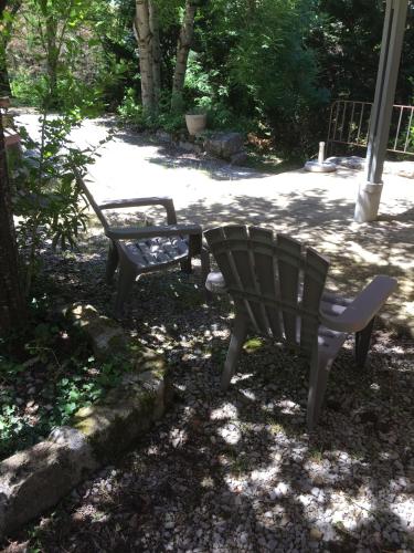 two chairs and a table in a yard at Manoir de Champvert in Les Vans