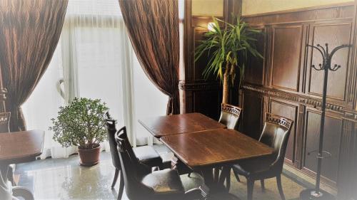una sala da pranzo con tavolo e sedie in legno di Хотел "АВЕНЮ" a Stara Zagora