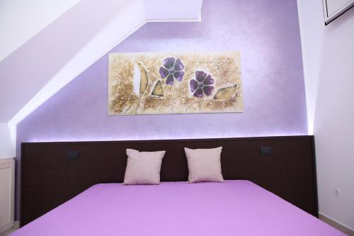 a bedroom with a bed with a purple wall at Villetta Sofia in Marina di Pescoluse