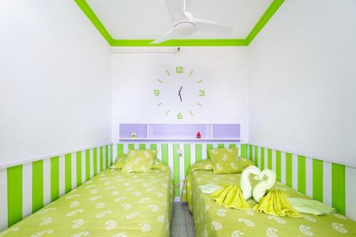 プエルト・デ・ラ・クルスにあるApartamento vistas al mar Valle Luzのベッド2台、壁掛け時計付きの客室です。