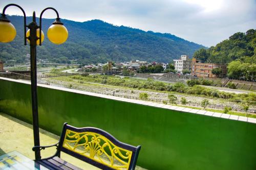 a bench sitting on a balcony with a view of a city at Lisin Village Homestay in Nanzhuang