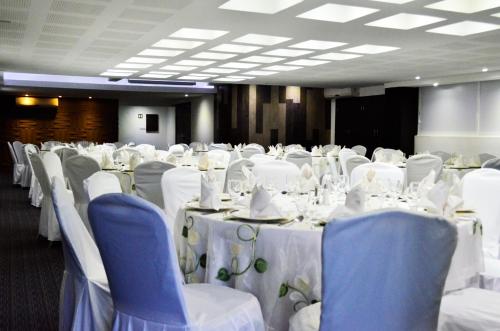 a room filled with tables and chairs with white table linen at LaiLa Hotel CDMX Reforma in Mexico City