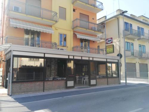 a building with a store front with windows at Hotel Bragozzo in Sottomarina