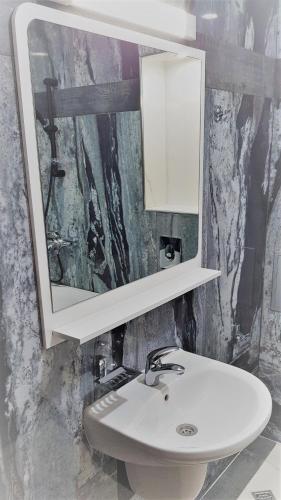 a bathroom with a white sink and a mirror at Хотел "АВЕНЮ" in Stara Zagora