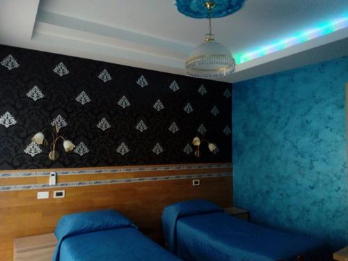 Habitación con 2 camas y pared azul en B&B DA DILETTA, en Rieti