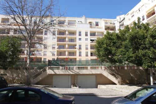 un estacionamiento frente a un gran edificio en Edificio Caravela C, en Armação de Pêra