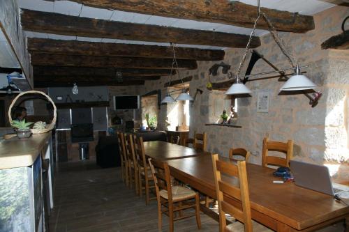 uma cozinha e sala de jantar com uma mesa de madeira e cadeiras em Chambre d'hôtes Le Cascadou em Banassac
