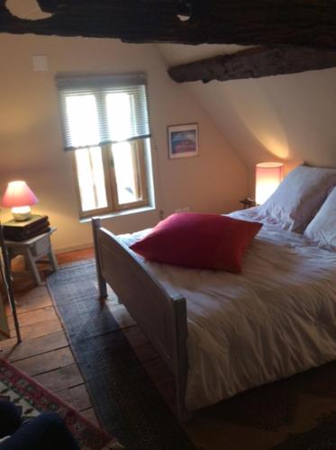 a bedroom with a large bed with a window at Ancien Relais de Poste in Collandres-Quincarnon