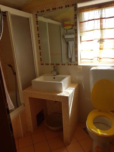 a bathroom with a sink and a toilet and a window at EDO-KROK in Baška