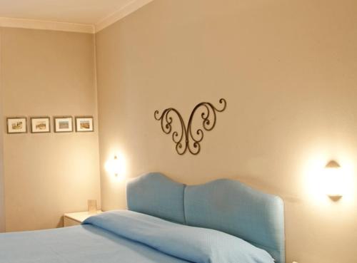 a bedroom with a blue bed and a sign on the wall at Hotel Locanda Mel in Calolziocorte
