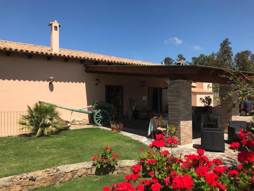 a house with red flowers in the yard at Hotel Belvedere in Teulada