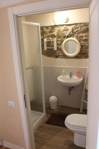 a bathroom with a sink and a toilet and a mirror at B&B Paradiso in Gubbio