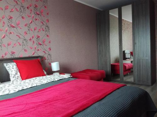 エカテリンブルクにあるApartament Red Islandのベッドルーム1室(ピンクの毛布と鏡付きのベッド1台付)