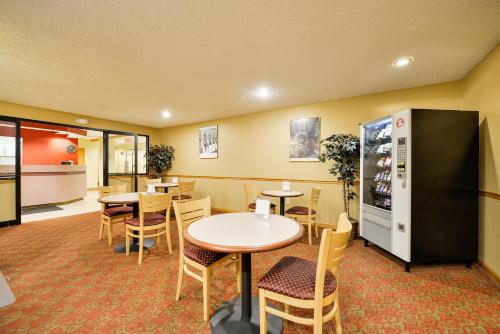 a restaurant with tables and chairs and a refrigerator at Americas Best Value Inn - East Syracuse in East Syracuse