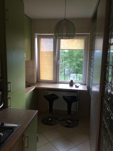 a kitchen with two bar stools and a window at Raj z haczykiem in Grzmięca