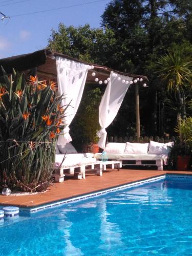 a pool with a gazebo next to a swimming pool at El Atico de Villalmar in Tui