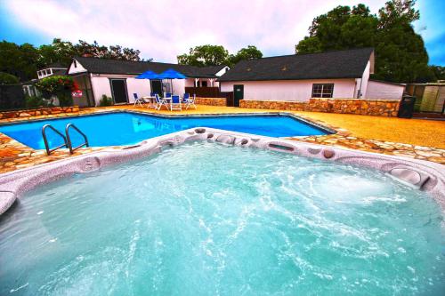 a large swimming pool in front of a house at Peach Tree Inn & Suites in Fredericksburg