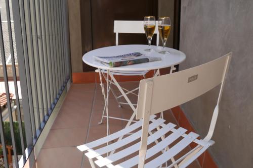 a white table and two glasses of wine on a balcony at Habitat Apartments ADN in Barcelona