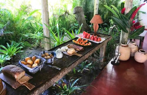 a buffet of food on a wooden table at Le Paxa Casa Hotel & Spa in Caraíva
