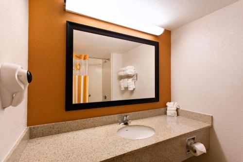 
a bathroom with a mirror, sink, and toilet at La Quinta Inn by Wyndham Orlando International Drive North in Orlando
