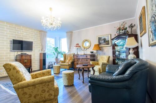 een woonkamer met meubilair en een kroonluchter bij Light, Spacious Apartment in the Heart of Belgrade in Belgrado