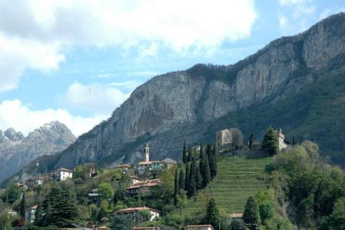 a village on a hill with mountains in the background at Hotel Locanda Mel in Calolziocorte