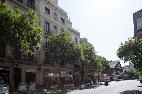 a street with buildings and trees on a city street at Habitat Apartments ADN in Barcelona