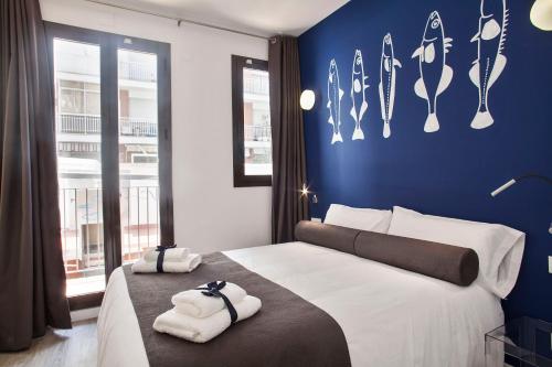 a bedroom with a large bed with towels on it at Habitat Apartments ADN in Barcelona