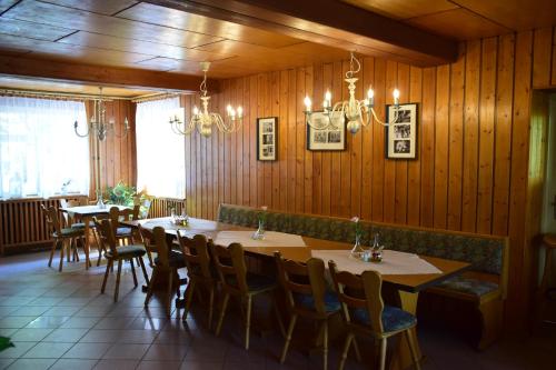 a dining room with wooden walls and tables and chairs at Gasthof Uttewalde in Uttewalde